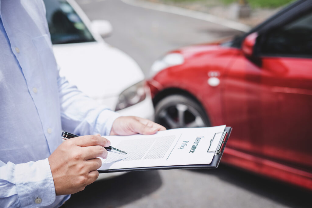 Traffic accident and insurance concept. Insurance agent working on a report form with a car accident claim process.
