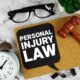 Personal Injury Law text on speech bubble with alarm clock and wooden gavel on marble background
