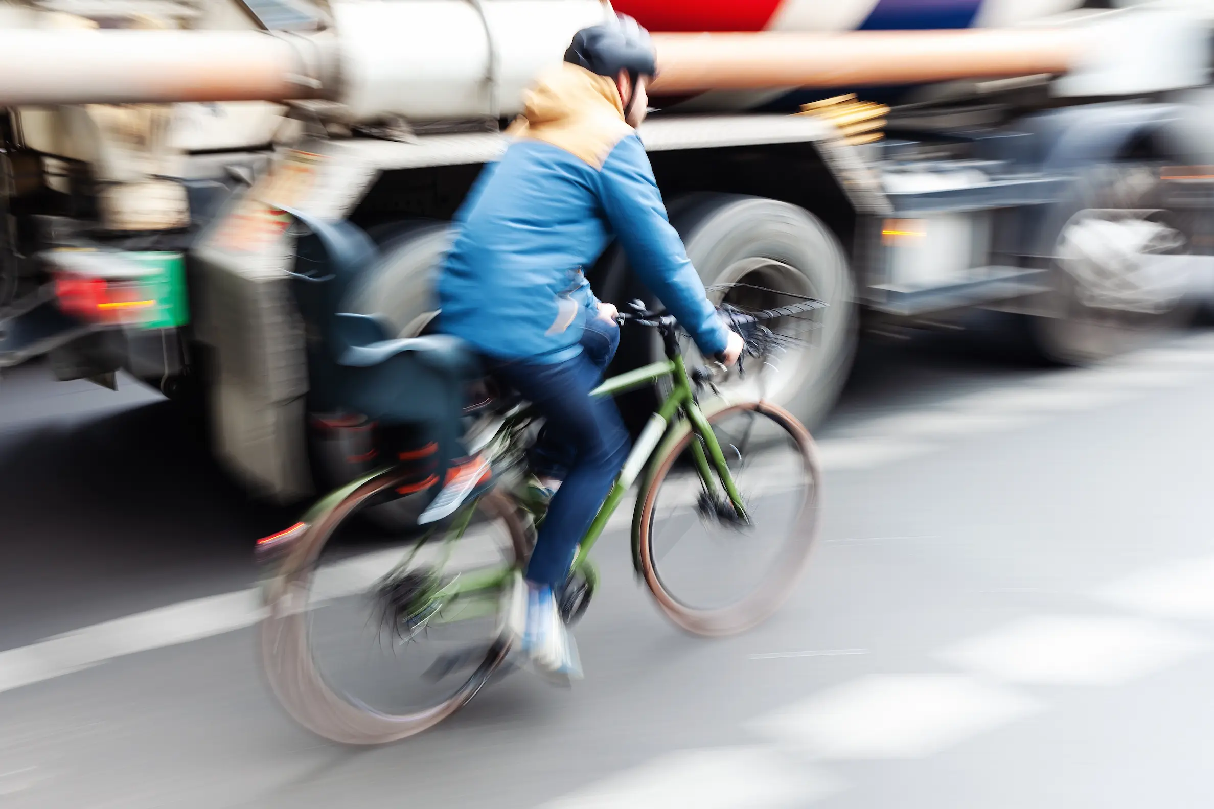 cyclist riding past a heavy truck