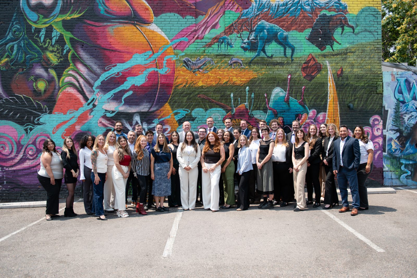 The CGH Injury Lawyers team, attorneys and staff, gathered in front of a mural in Denver, Colorado.